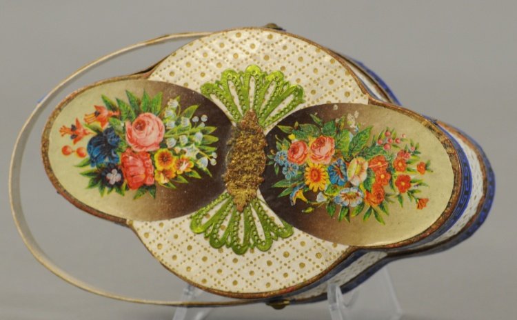 A LADIES CARRY BASKET DRESDEN: A large Dresden handled basket, wonderful detail and colors throughout, top removes for candy or gift retrieval. 5". Ex. Tom Fox Collection