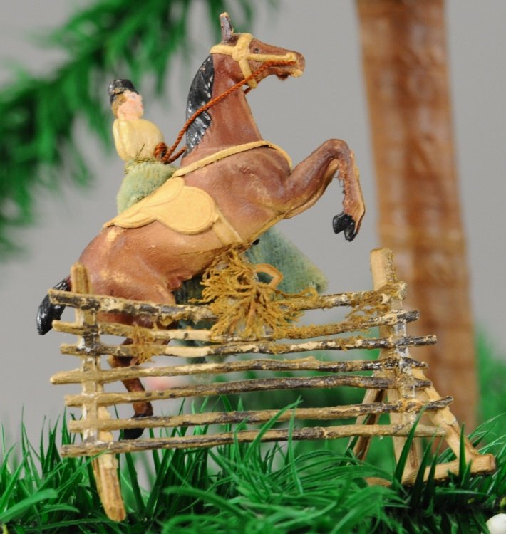 EQUESTRIAN LADY GERMAN DRESDEN: Lady in green dress sitting side saddle, jumping barrier, Dresden Christmas tree ornament. 3 1/2".