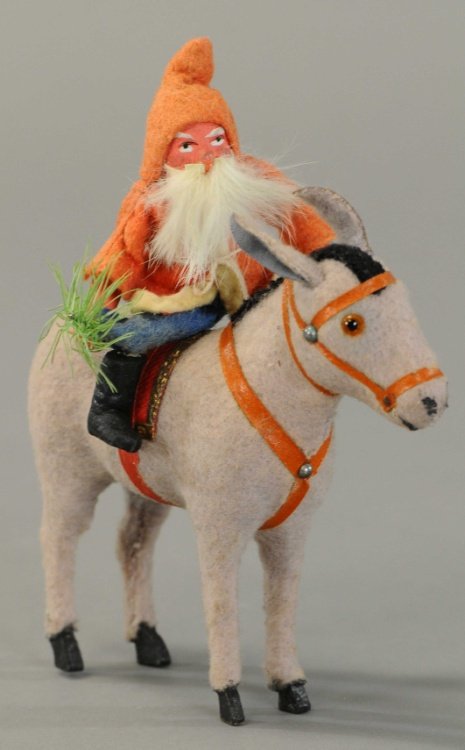 SANTA CLAUS ON DONKEY: Germany, composition Santa, rabbit fur beard, holding feather sprig, on grey felt covered donkey with glass eyes and all of his trappings. 6".
