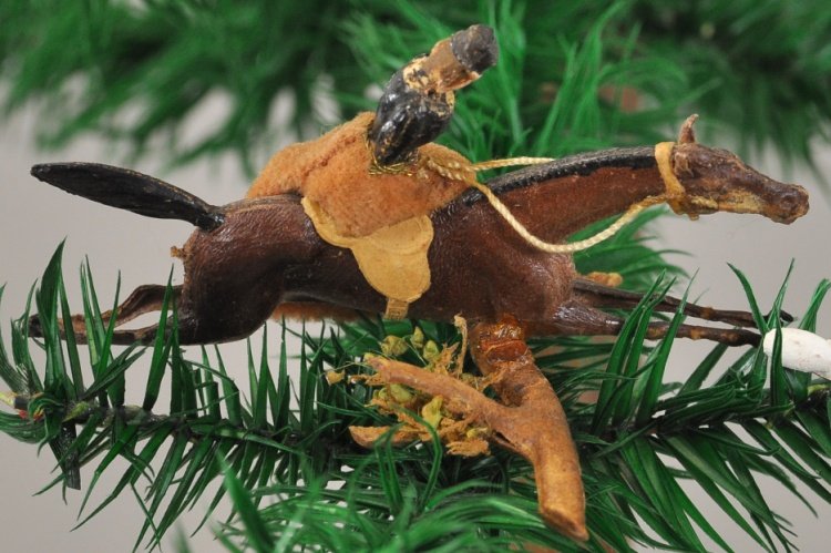 EQUESTRIAN FIGURE WITH LOG OBSTACLE: Rider has black blouse and orange velveteen long skirt, brown horse in full extension to clear logs with leaves and moss. 1 1/2" x 3 1/2".