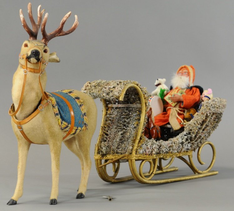 CLOCKWORK REINDEER NODDER WITH SANTA ON SLEIGH: Magnificent frosted lichen sleigh, Santa Claus with bisque doll at his side surrounded with wonderful toys, pulled by exceptionally well detailed clockwork nodding reindeer, complete with all of his t