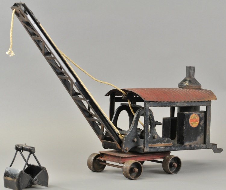 BUDDY 'L' CLAMSHELL DREDGE: C. 1920's, pressed steel, black housing with upright boiler, red roof, black boom clamshell, roller wheels on red frame, early circular decal. 30" l.