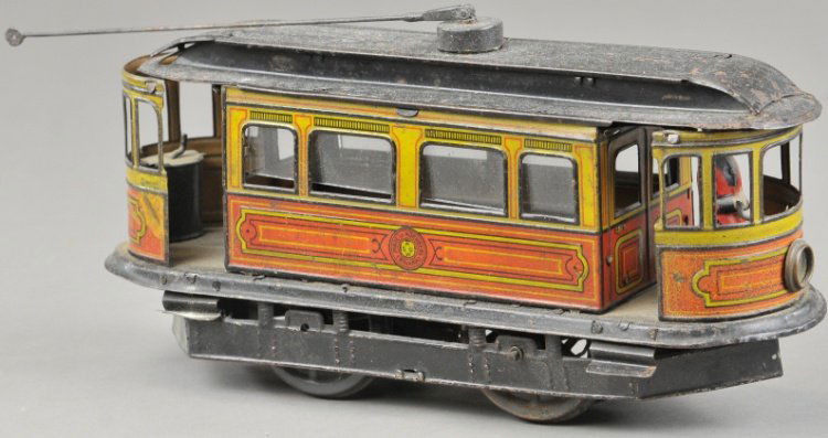 GUNTHERMANN TROLLEY: Germany, lithographed tin body, black roof with pole affixed at center, clockwork driven, conductor sands at one end, open doors at both ends. 10" l.