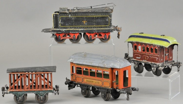 GROUPING OF EUROPEAN TRAIN CARS: Lot includes gauge I Marklin passenger car, Marklin stock car, Bing passenger coach and Marklin eight wheeled tender. Longest 9" l.