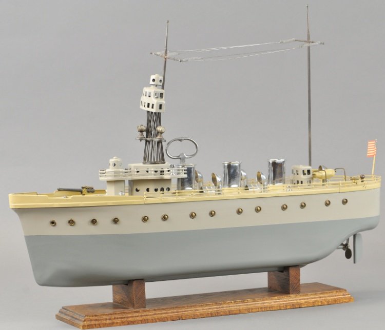 ORKIN BATTLESHIP B3: Heavy pressed steel design, painted in beige with grey hull, features fire control towers, masts connecting wiring, deck mounted gun, well appointed deck with platform, clockwork driven. 24" l.