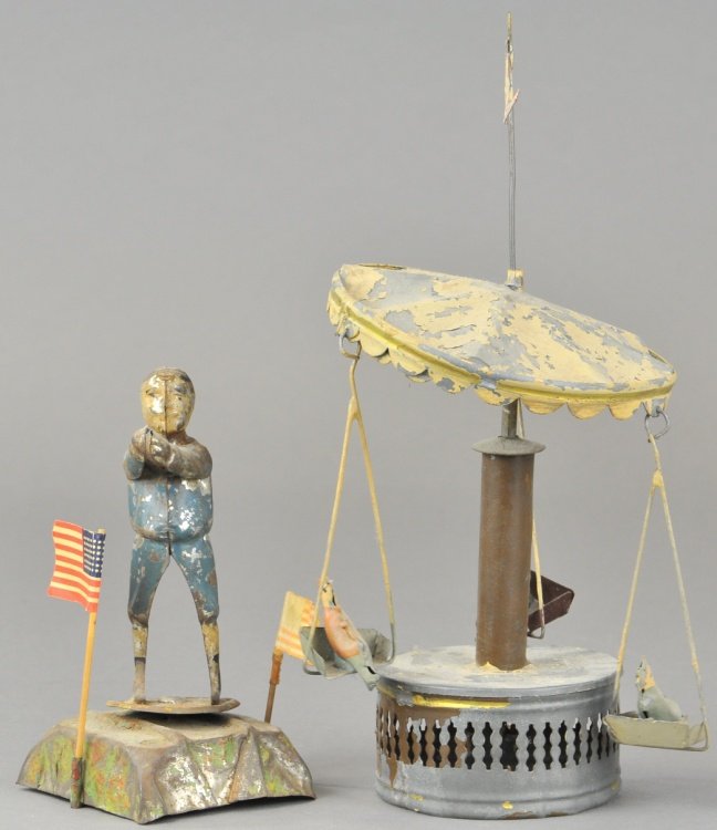 LOT OF TWO TIN WIND UP TOYS: Germany, includes boy on base and small roundabout, both have poor paint condition, boy's wind up mechanism overwound. 5 1/2" to 10" at flag.
