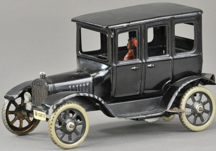 BING CENTER DOOR SEDAN: Painted in black overall, tin auto features spare on rear, seated driver, spoke wheels, hood ornament, clockwork driven. 8 1/2" l.