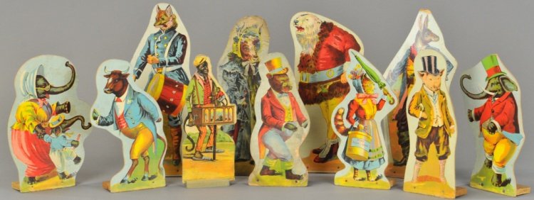 WHIMSICAL ANIMAL DIE CUTS: Cardboard lithographed die cuts depict suited animals, amusing graphics, each with wooden base, probably used as skittle set or targets, includes eleven pieces. 9" to 11 1/2".