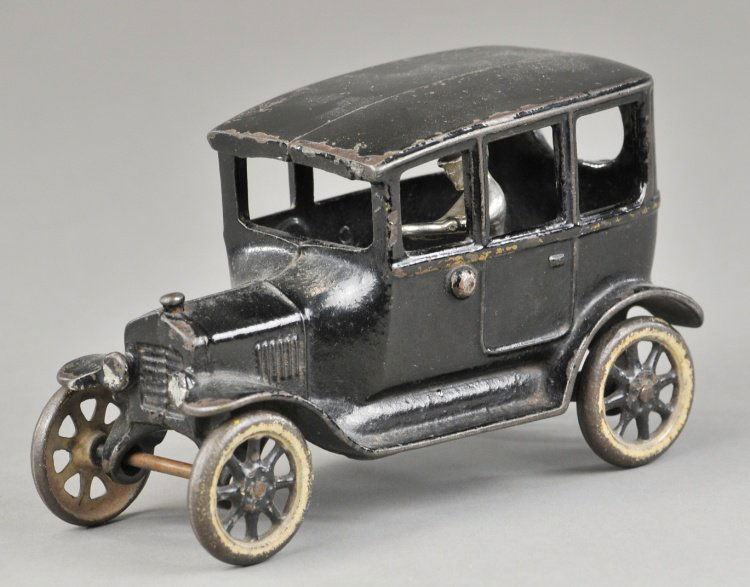ARCADE MODEL 'T' CENTER DOOR SEDAN: Cast iron, painted in black with gold highlighting, seated nickel driver, painted spoke wheels. 6 1/2" l.