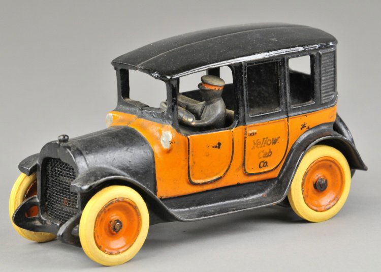 ARCADE YELLOW CAB: c. 1940, cast iron, painted in bright orange color, decal on side reads "Yellow Cab" on door, passenger, white rubber tires, folding luggage rack on trunk. 8 1/4" l.