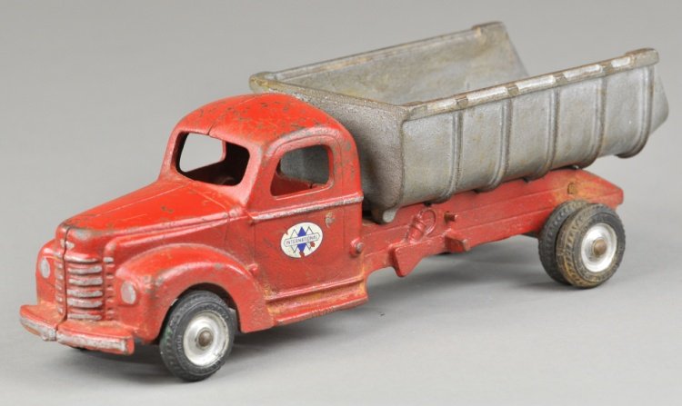 INTERNATIONAL DUMP TRUCK: Arcade, cast iron, enclosed red cab with tilting silver dump body, decal on door, rubber tires, dual on rear. 10 1/2" l.