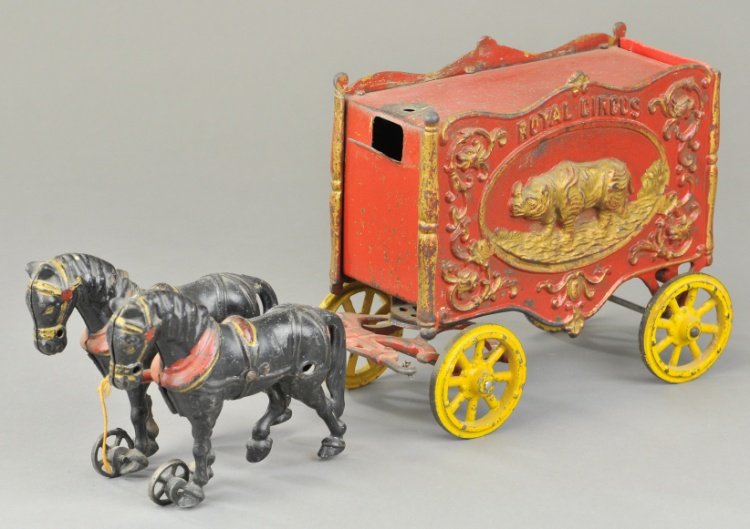 HUBLEY CIRCUS VAN WAGON: Ornate Royal Circus parade wagon with heavy embossed relief of rhino on sides, pressed steel roof top, drawn by team of black horses with wheels at front feet. 16" l.