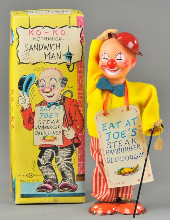 KO-KO MECHANICAL SANDWICH MAN TIN TOY: Japan, Nomura, wears cloth outfit, tin shoes, vinyl head, wears paper litho placard which reads "Eat at Joe's," action allows him to tip hat. 6 3/4" h.