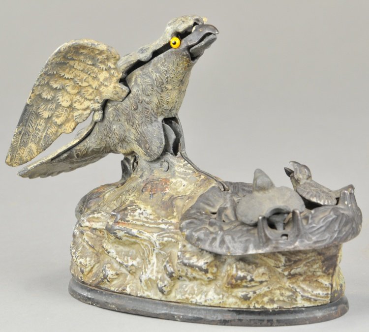 EAGLE & EAGLETS MECHANICAL BANK: J & E Stevens Co., designed by Charles M. Henn, Chicago, IL, patented 1/23/1883. Place a coin in the eagle’s beak, press the lever and the eaglets rise from the nest, actually crying for food. As th