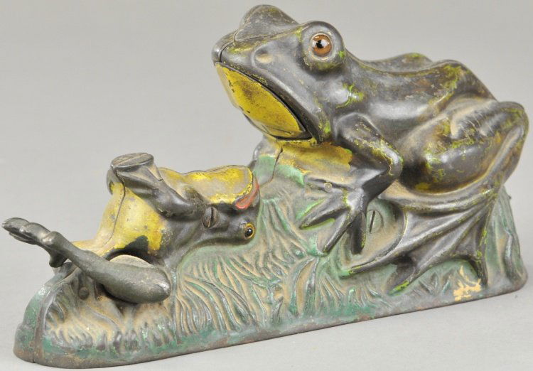 TWO FROGS MECHANICAL BANK: J & E Stevens Co., designed by James H. Brown, patented 8/8/1882. Place the coin on the young frog. Press the lever, and the old frog will open its mouth, catch and swallow the coin which the young fr