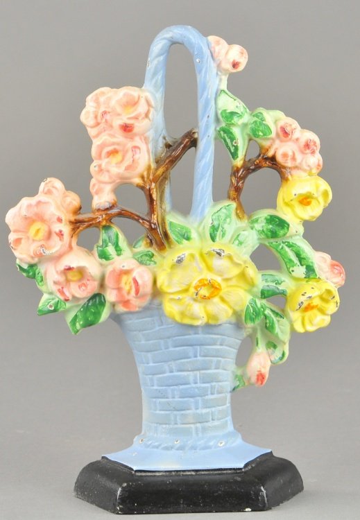 APPLE BLOSSOM DOORSTOP: Marked "Hubley 329," cast iron depicts apple blossoms on branch arranged on blue wicker basket with handle, beautiful colors. 7 5/8" x 5 1/2".