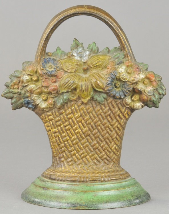 B&H MIXED FLOWERS DOORSTOP: Bradley & Hubbard, wicker weaved basket with handle holds a mix of flowers on green box, marked B&H. 8 1/8" x 6 7/8".