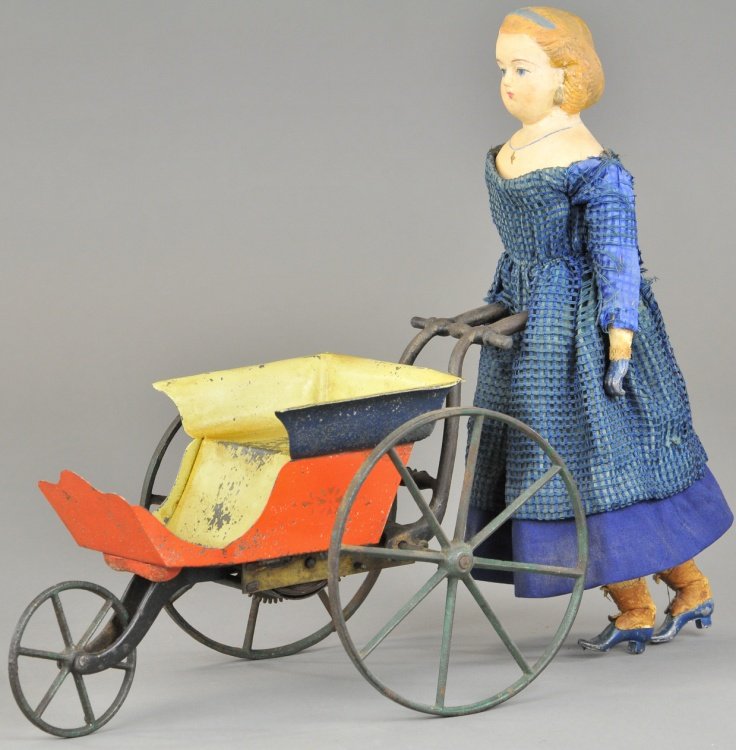 AUTOMATIC WALKING DOLL: c. 1880's, Stevens & Brown, Goodwin patent, exceptional condition tin sleigh painted in red and blue, gold stenciling, cast iron spoke wheels, young girl has hand painted composition head, lead hands 