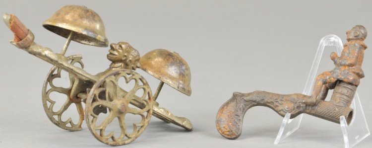 DOUBLE BLACK HEAD BELL TOY & CLOWN FIRE CRACKER: Ives toy cap gun depicts man seated on powder keg, together with Gong Bell double bell ringer example in nickeled cast iron, missing wooden handle. 6" l.