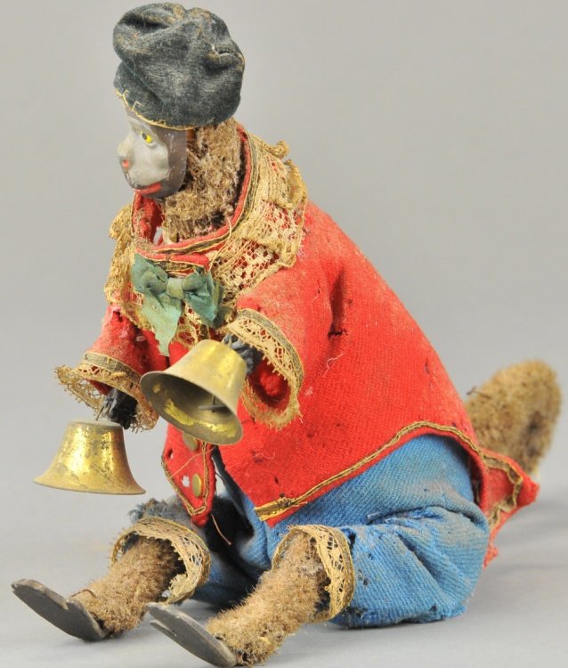 IVES CLOCKWORK MONKEY BELL RINGER: An all original example, amusing toy depicts a seated monkey holding bell in each hand, felt covered fur, hand painted face, clockwork action, allows head and hand movement while monkey bows. 9" h.