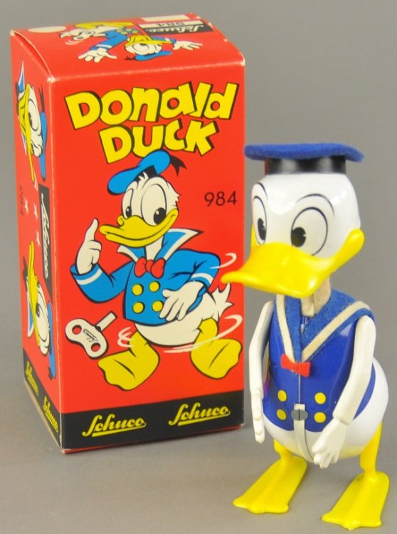 SCHUCO DONALD DUCK: Western Germany, boxed example, copr. Walt Disney Prod., brightly painted tin body with plastic feet, arms and beak, waddles while opening and closing mouth when wound. Figure 6" h.
