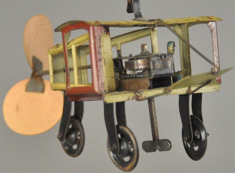 CIRCLING AIRPLANE ON BASE: Fischer, Germany, tinplate toy monoplane with weight on one end, able to fly around base circling wire support. 16" h.