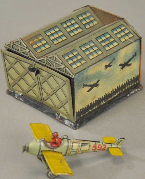 HANGAR WITH AIRPLANE PENNY TOY: Distler, Germany, lithographed tin, includes single prop example with seated pilot and well detailed hangar with opening bay door. Hangar 3" x 3".