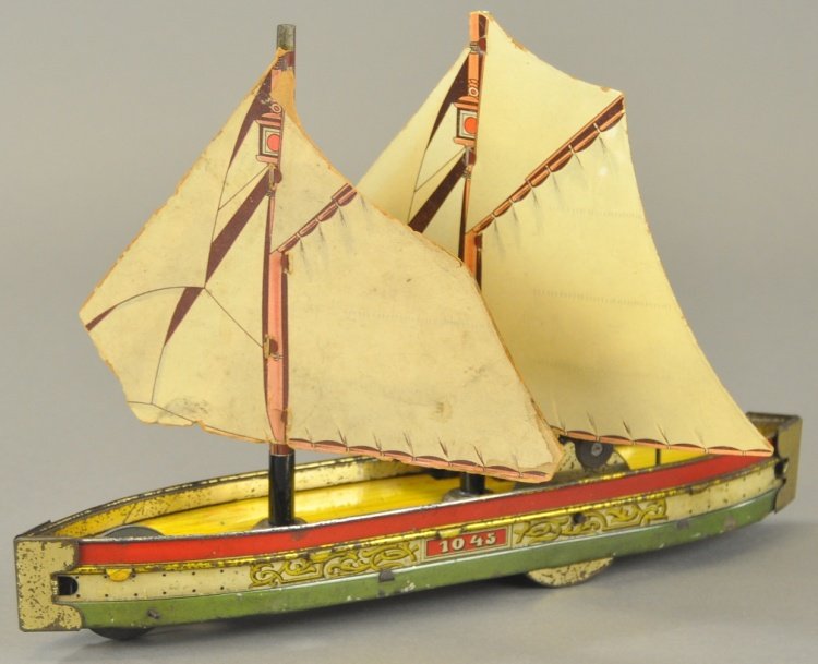 HESS SAILBOAT: Germany, #1045, flywheel powered, lithographed tin, features dual cardboard sails, nice graphics to simulated cloth sails, hull done in bright red, white, and green, simulated wood deck planking. 11 3