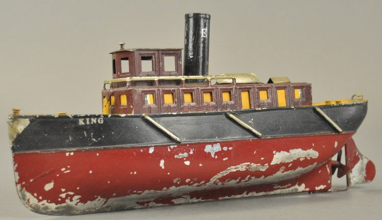 IVES TUG BOAT: Tin vessel painted in maroon and black hull, features single stack, upper deck cabin and pilot's house, clockwork driven, side reads, "KING." 10 1/2" l.