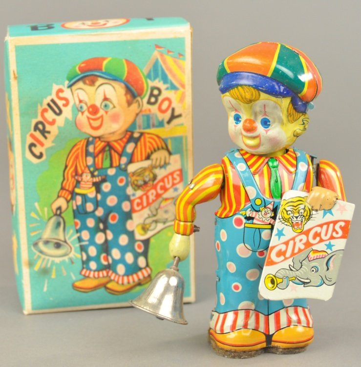 CIRCUS BOY TIN TOY: Japan, lithographed tin, depicts young boy in colorful outfit holding circus placard and bell in hand which rings when clockwork is activated, includes original box. 6 1/4" h.