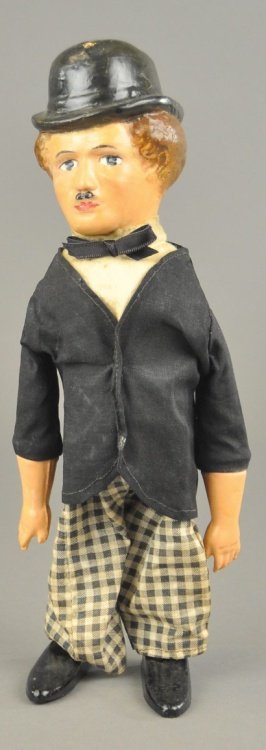 CHARLIE CHAPLIN WALKER: Large figure, done in painted composition head, cloth outfit and tin shoes, wind-up action allows waddling motions. 11 1/2" h.