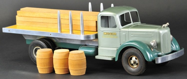 SMITH MILLER L-MACK MATERIAL TRUCK: Very early example, one of the finest Macks made by Smith Miller, circa 1950, die-cast cab, painted in two-tone greens, flat bed body has polished aluminum sides and posts, comes with three barrels an