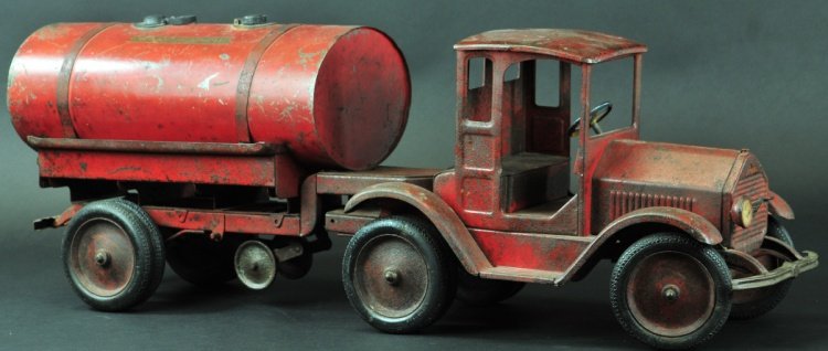 STUDITOY OIL TRUCK: Pressed steel, tandem done in red, features doorless cab with tank body, filler caps on top, decals and spigot on rear of body, sold as-is, this example has been restored in places and cab is a marria