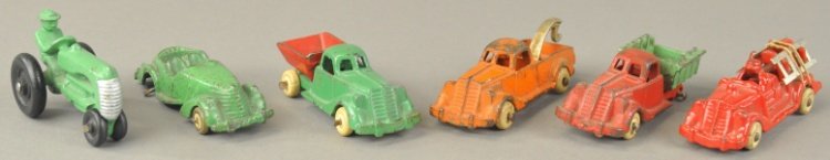 GROUPING OF HUBLEY MIDGET LINE VEHICLES: Cast iron, includes wrecker, stake truck, dump truck, ladder truck, tractor and open Roadster with back wheel missing. 3 1/2" - 3 3/4" l.