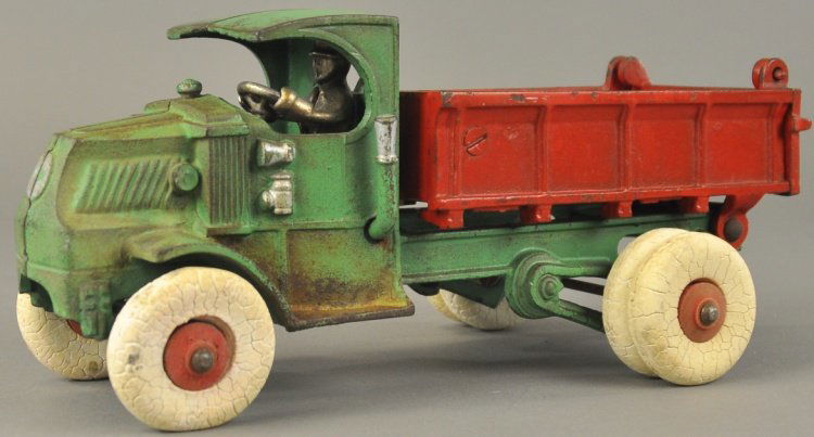 HUBLEY MACK DUMP TRUCK: Cast iron, 'C' Mack cab, painted in green cab and red body, dump bed has opening tailgate, white rubber tires with dual set on rear. 10 1/2" l.