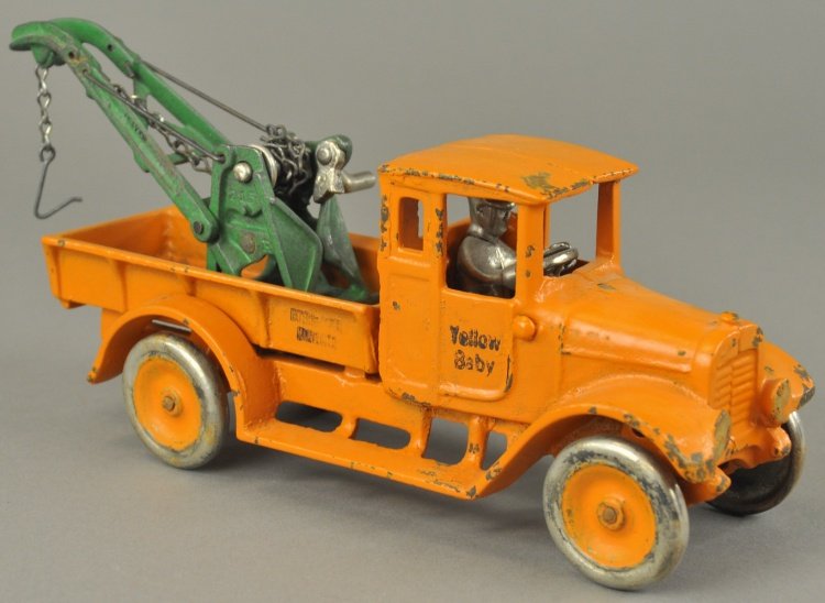 YELLOW BABY: Arcade, cast iron, painted in orange overall, stamped "Yellow Baby" and "International Harvester" on doors and bed, Weaver wrecker boom mounted in bed. 11" l.