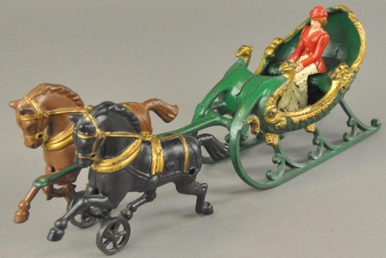 HUBLEY SLEIGH: Cast iron open sleigh painted in green body with gold highlights, drawn by two horses, one brown, one black, features seated woman figure. 14" l.