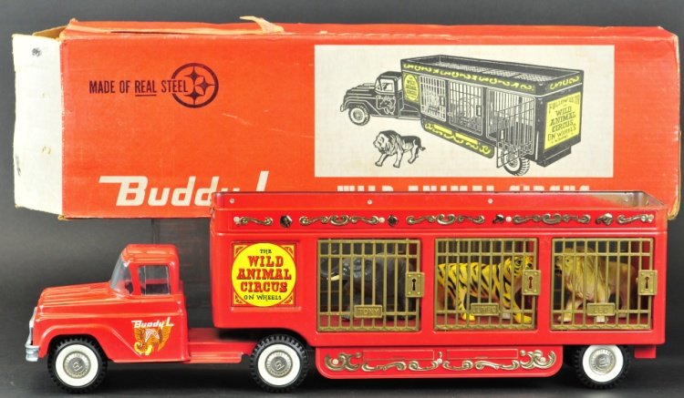 BUDDY 'L' WILD ANIMAL CIRCUS TRUCK WITH BOX: No. 5477, c. 1969, pressed steel, red cab pulls long cage sided body housing three plastic animals, very ornately embossed, colorful decals. 26" l.