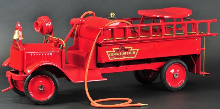 KEYSTONE PACKARD CHEMICAL PUMP ENGINE RIDE-ON: c. 1926, pressed steel, painted in red overall, low open cab and service body, features side mounted ladders, water tank and hose reel, rubber tires, disc wheels, railed rear platform. 27" l.