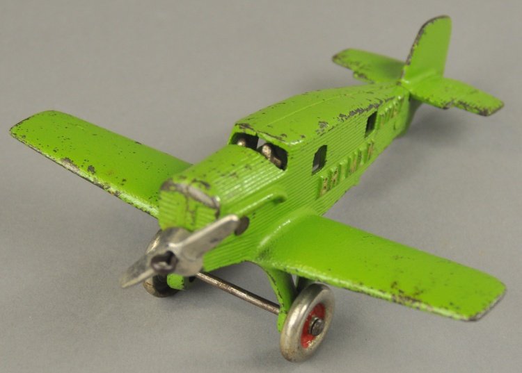 HUBLEY "BREMEN JUNKERS" AIR CARGO PLANE: Late 1920's, cast iron, modeled after the first Atlantic crosser, painted cast iron, done in green, embossed "Bremen" on fuselage. airplane contains two pilots and flyer at window, nickel disc wheels 