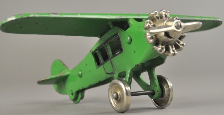 DENT "LUCKY BOY" AIRPLANE: c. 1930's, cast iron monoplane, painted in green overall, nickeled motor and propeller, embossed "Lucky Boy" on wing, nickel disc wheels. 9 3/4" wingspan.