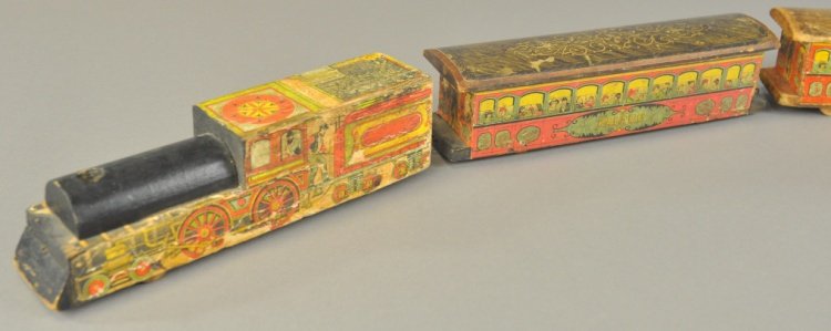 PALACE FLOOR TRAIN: Attributed to Milton Bradley, "Palace" floor train in colorful lithographed paper on solid wood, includes two passenger trains, loco has integral tender, wheels inset in bases. Loco 11" l.
