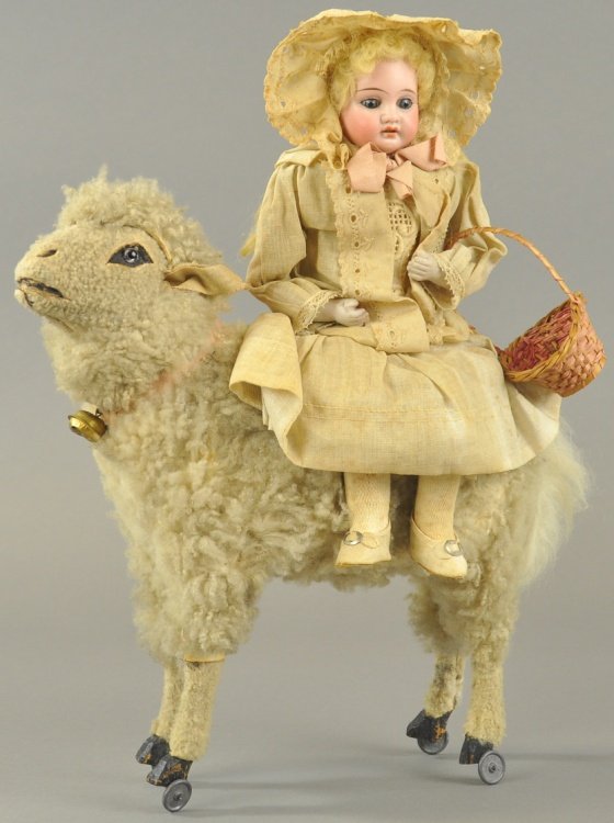 BISQUE HEAD "LITTLE BO PEEP" ON SHEEP: Germany, beautiful bisque head doll, glass eyes, holding basket, sitting on wooly sheep with glass eyes and brass bell pull toy, an impressive early child's toy. 14" h.