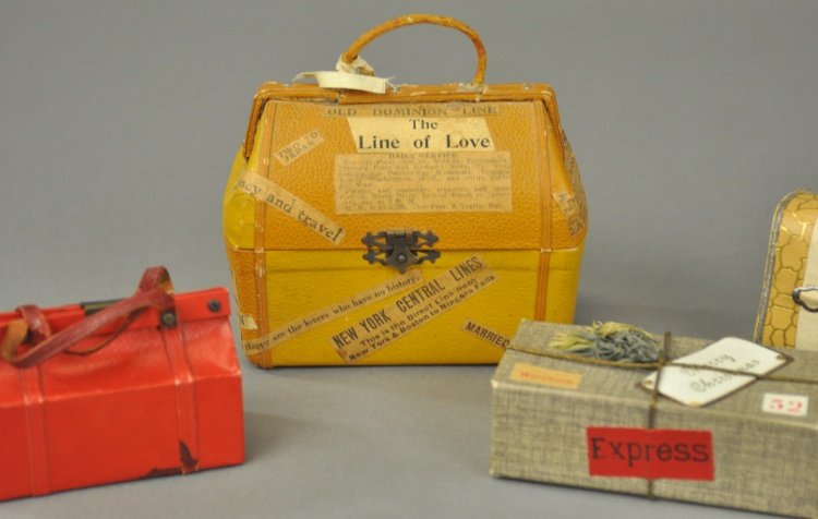 * GROUP OF FOUR TRAVEL LUGGAGE CANDY CONTAINERS: Germany, three leather satchels and a shipping box with "Merry Christmas" tag, all well molded examples. 3" - 4 1/2" l.