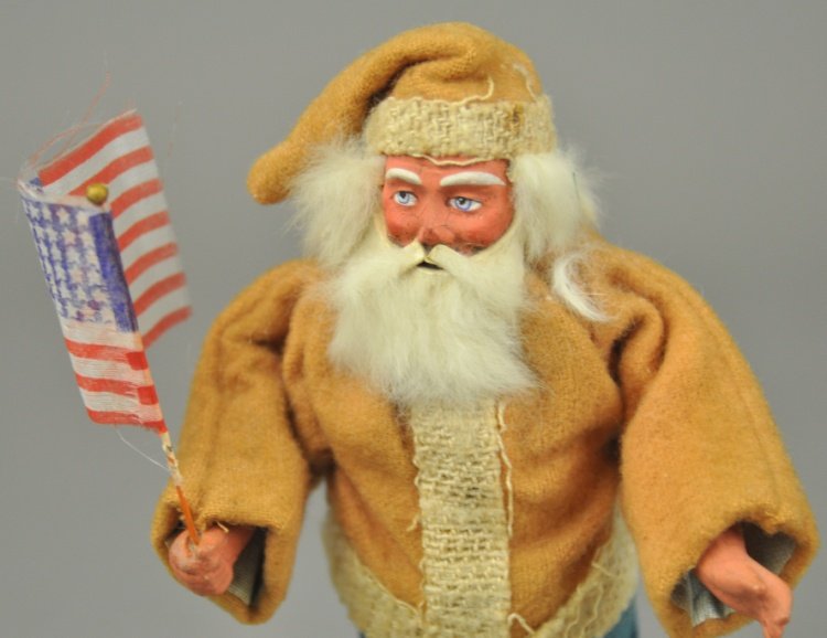 * SANTA CLAUS CANDY CONTAINER: Germany, purposeful looking Santa, articulated arms, composition face with rabbit fur beard, separates at waist for candy retrieval, missing his feather tree sprig. 7" l.