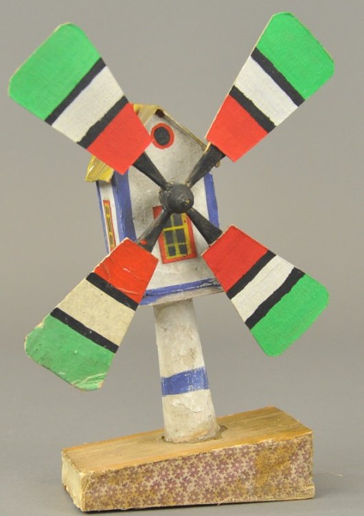 GERMAN MECHANICAL WINDMILL: Early hand painted wood and composition windmill, squeeze the base and the blades turn, whimsical child's toy. 8" h.