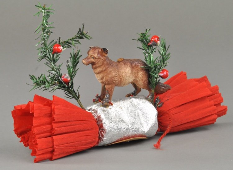 * DRESDEN FOX POPPER: German Dresden, sly fox looking out from behind feather tree sprig, mounted on red Christmas burst popper. 9" l.