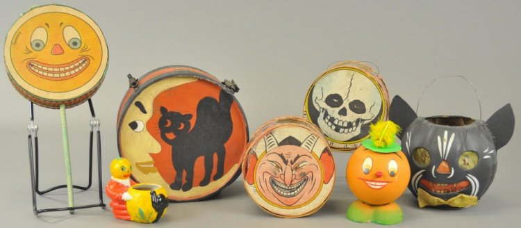 GROUPING OF SEVEN HALLOWEEN DECORATIONS: A black cat lantern, two Halloween drum lanterns, cloth face pumpkin man noisemaker, pumpkin man candy container, and ceramic pumpkin man candy container, along with a Halloween child's drum with cat