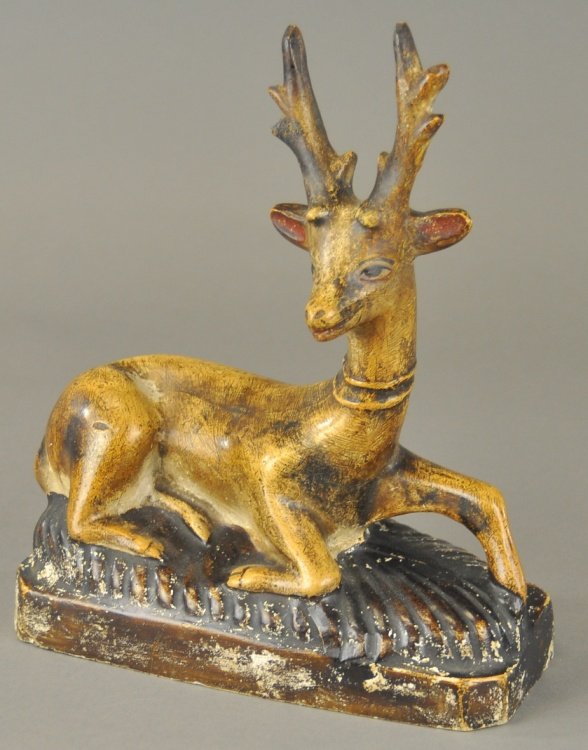 FOLK ART CHALKWARE REINDEER: A whimsical folk art depiction of a reclining reindeer, done in painted and fired chalkware, (poured plaster) finely detailed expression, rarely seen example. 10" h.