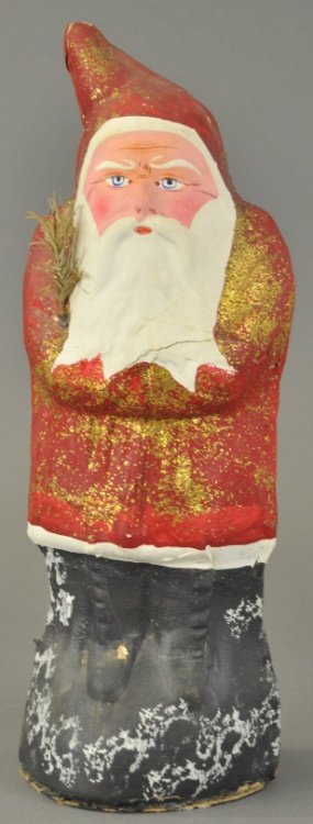 * LARGE PRESSED CARDBOARD SANTA: Germany, pressed and stapled Belsnickle, candy container, feather tree sprig in arm, plug in base opens for candy retrieval. 15" h.